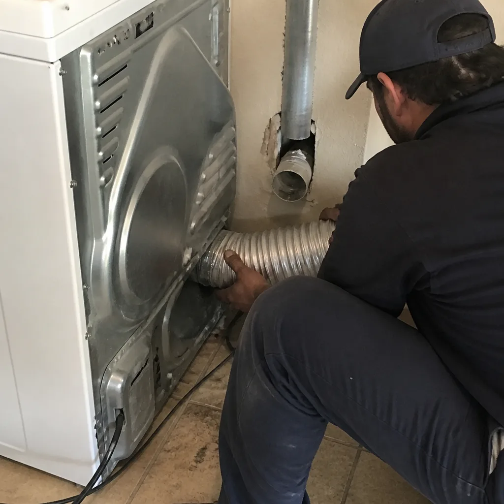 Technician connecting flexible dryer vent hose for professional maintenance service in Fort Worth, TX